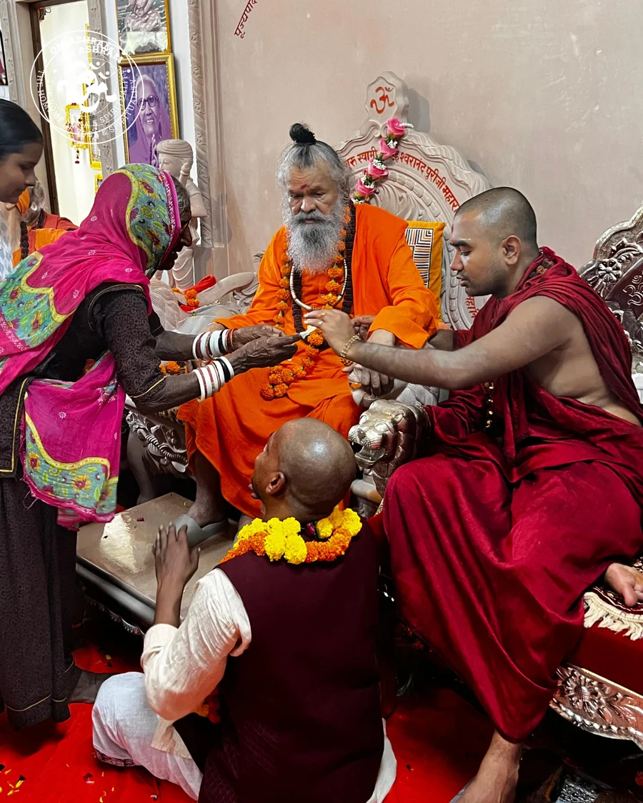 A devotee bowing in respect to Gurudev with a look of joy.